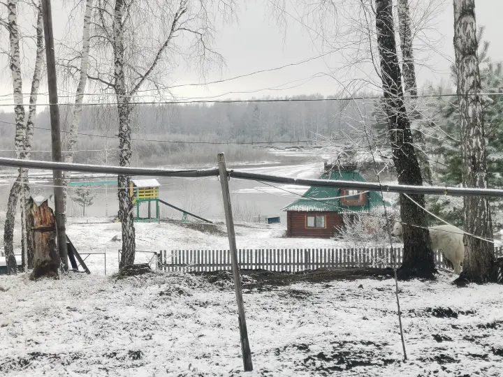Деревянный дом и берег реки зимой