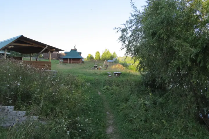 Тропинка между деревянными постройками летом