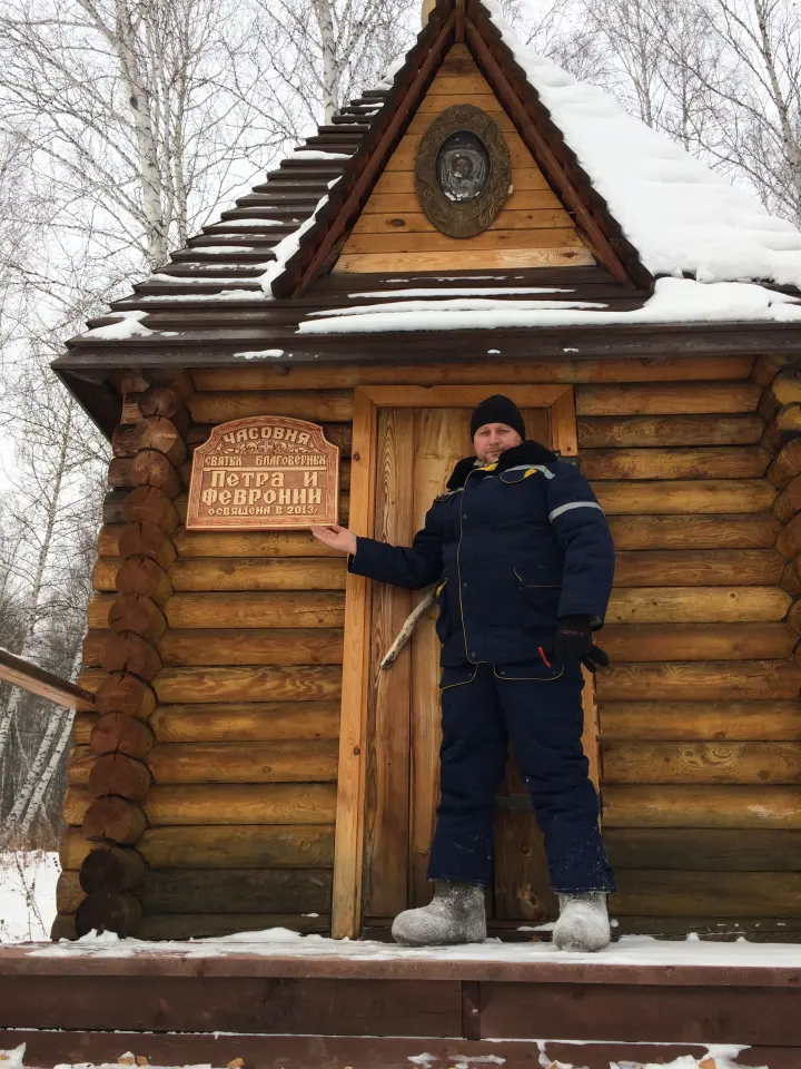 Гость у входа в деревянный дом зимой