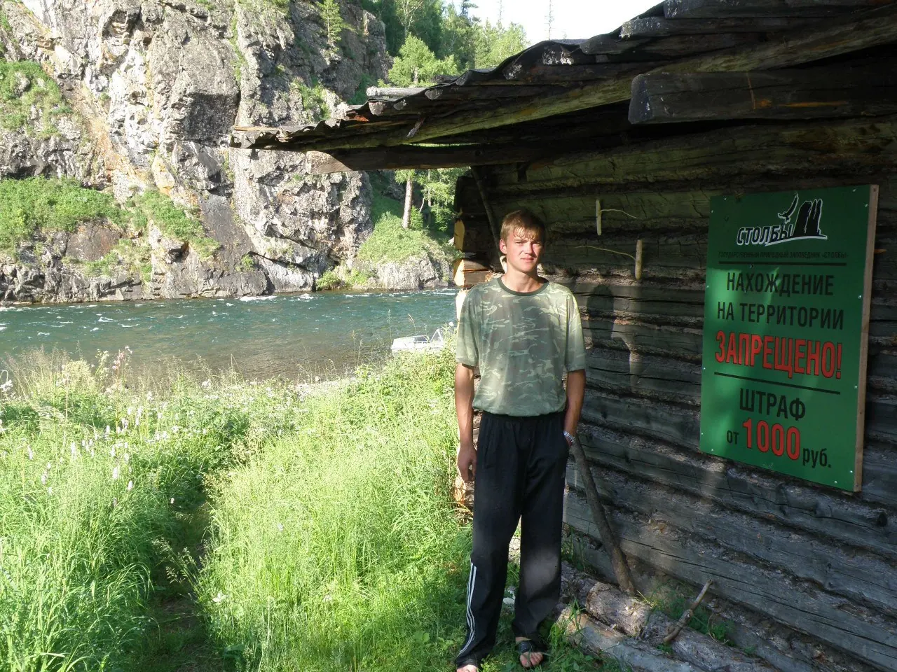 Путешественник у таёжного зимовья в скалах